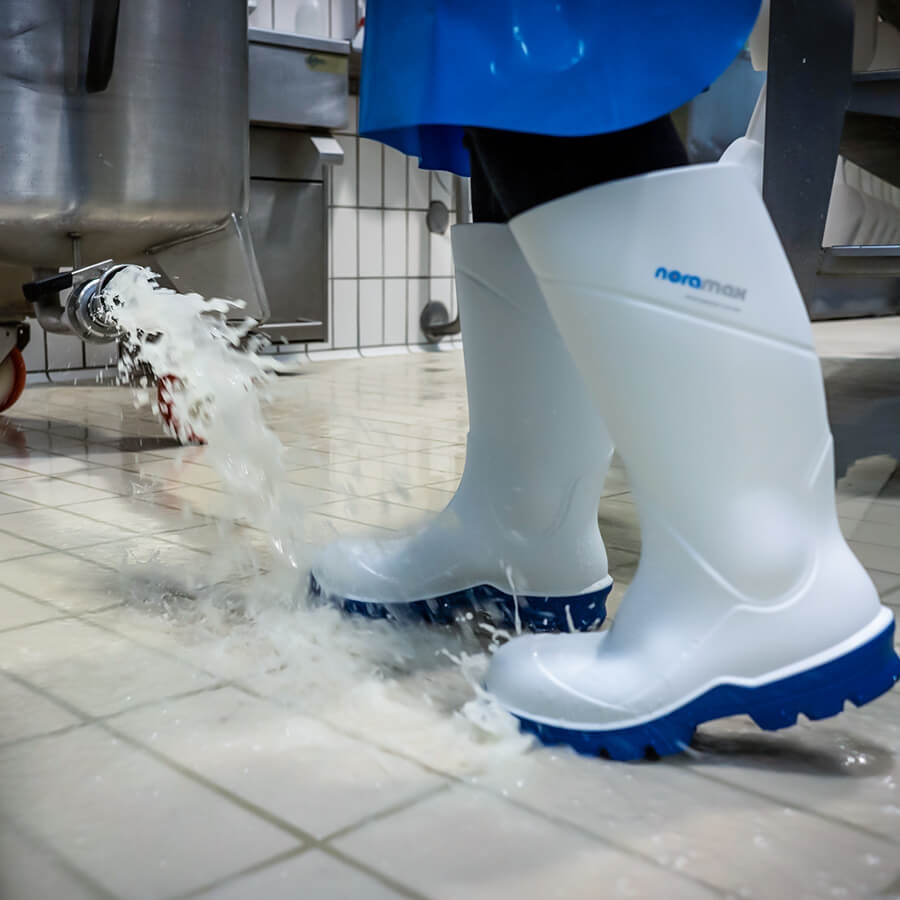 Detalle de botas industriales Noramax Food S4 en entorno húmedo de planta laboral Colombia, suela antideslizante SR, dotación Intremaq